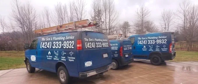 The Son's Plumbing Service vans parked with ladder racks